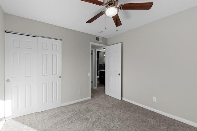 unfurnished bedroom with ceiling fan, a closet, and light carpet