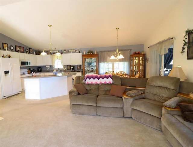 carpeted living room with an inviting chandelier and vaulted ceiling