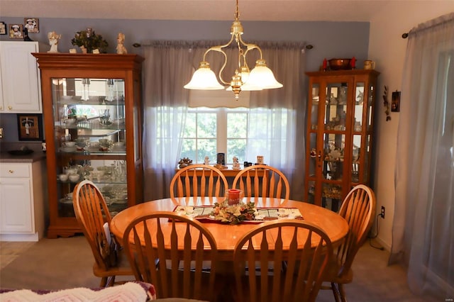 dining space with carpet and a chandelier