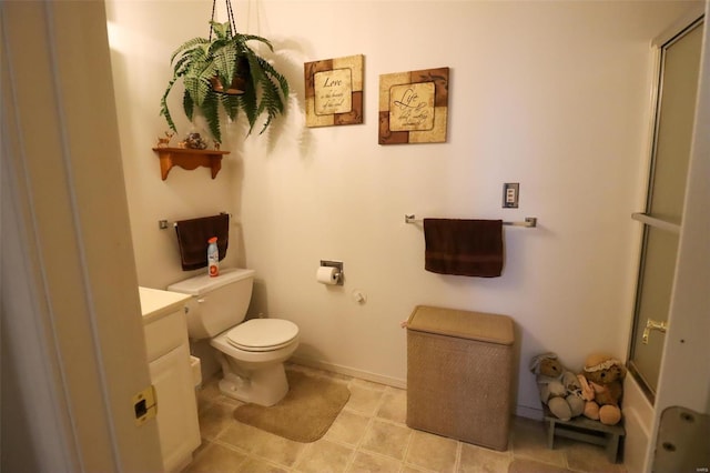 bathroom with vanity, toilet, and a shower with door