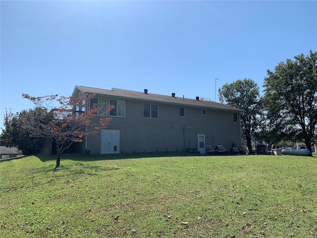 rear view of house featuring a yard