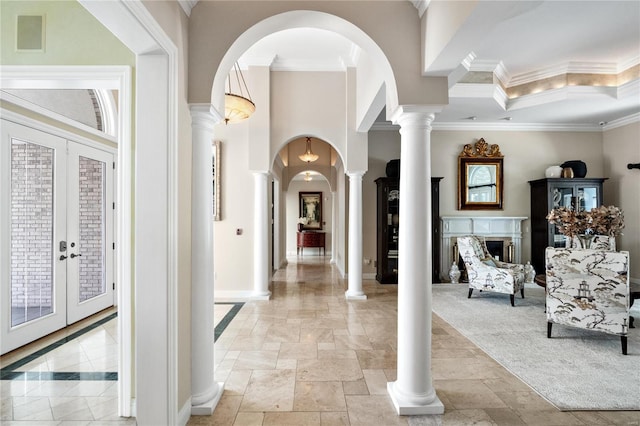 foyer entrance with a high ceiling, ornate columns, crown molding, light carpet, and french doors