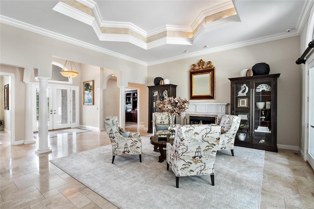 living room featuring ornamental molding, a tray ceiling, and decorative columns