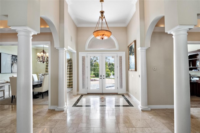 foyer entrance with a towering ceiling, french doors, crown molding, and an inviting chandelier