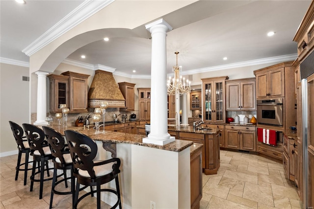 kitchen with a kitchen breakfast bar, kitchen peninsula, backsplash, appliances with stainless steel finishes, and ornamental molding