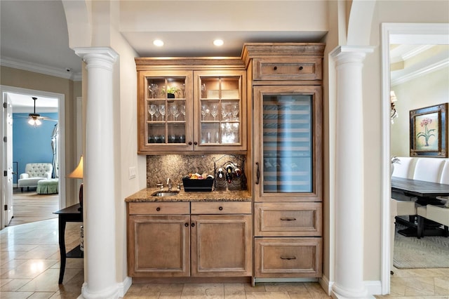 bar with light stone counters, ceiling fan, tasteful backsplash, crown molding, and wine cooler