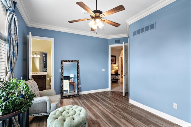 sitting room with hardwood / wood-style flooring, crown molding, and ceiling fan