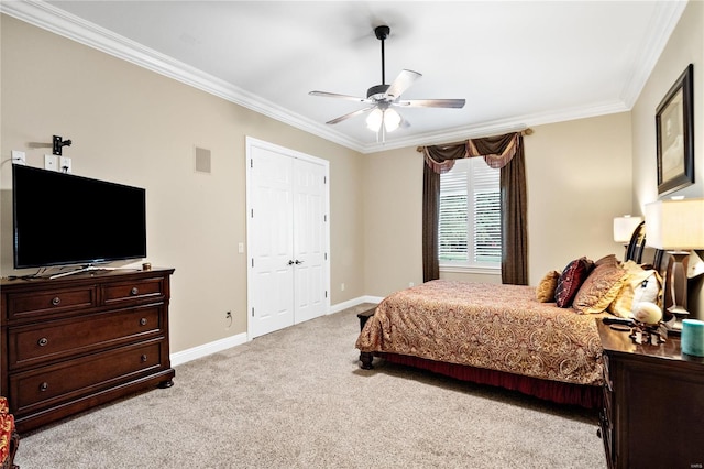 carpeted bedroom with ornamental molding, ceiling fan, and a closet