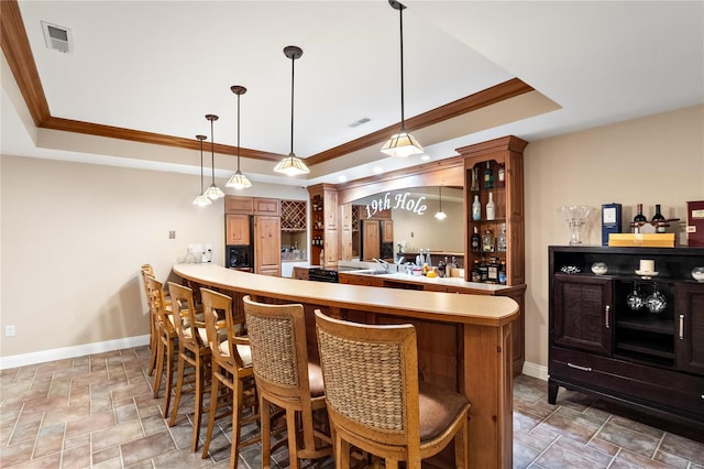 bar featuring a raised ceiling, pendant lighting, crown molding, and sink