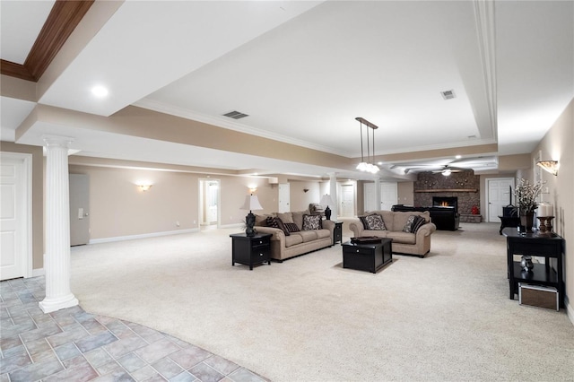 carpeted living room with ornate columns, ornamental molding, a fireplace, and ceiling fan