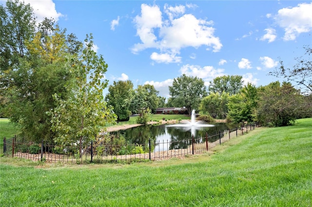 surrounding community with a water view and a lawn