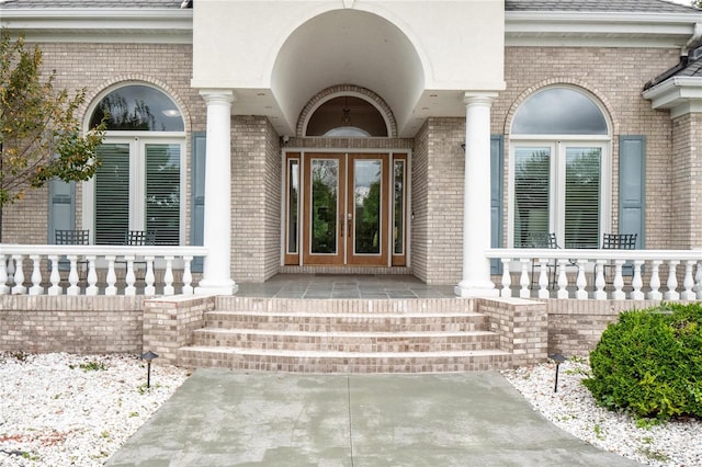 doorway to property featuring a porch and french doors