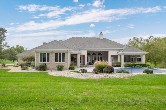 rear view of property featuring a yard and a patio area