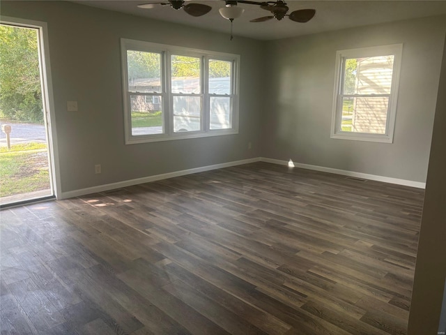 unfurnished room featuring a wealth of natural light, dark wood-type flooring, and ceiling fan