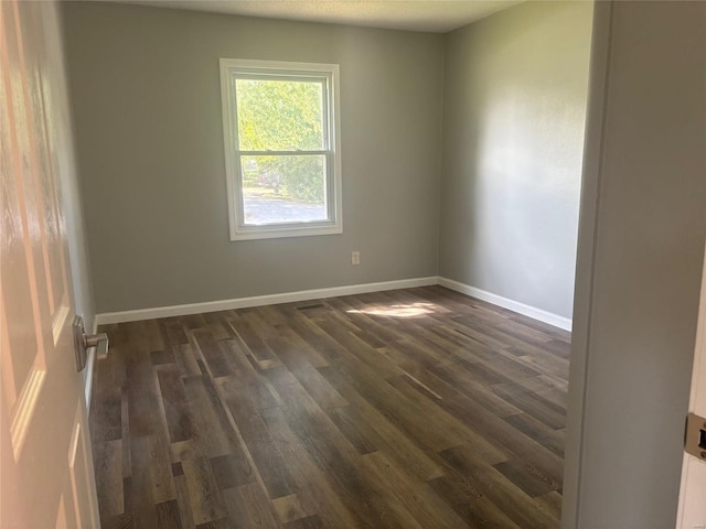 unfurnished room with dark hardwood / wood-style flooring