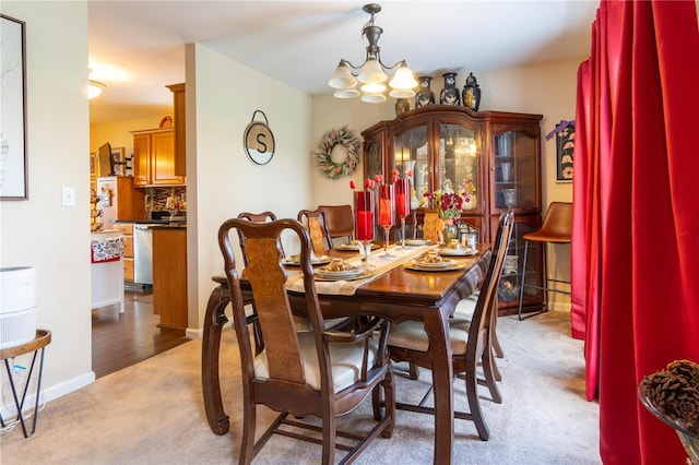 carpeted dining space featuring a notable chandelier