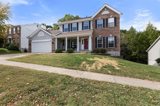 colonial house featuring a front yard, a garage, and a porch