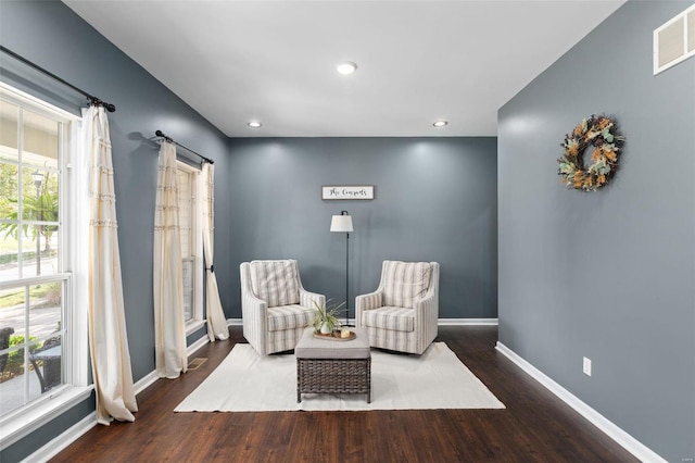 sitting room with a barn door and hardwood / wood-style flooring