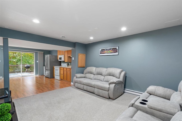 living room featuring a baseboard heating unit and light hardwood / wood-style flooring