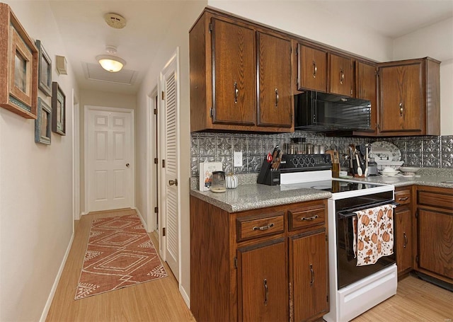 kitchen featuring backsplash, light hardwood / wood-style floors, and white electric range