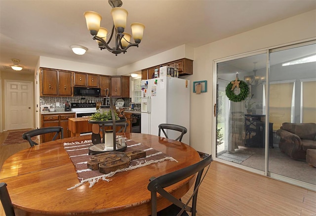 dining space featuring an inviting chandelier and light hardwood / wood-style flooring