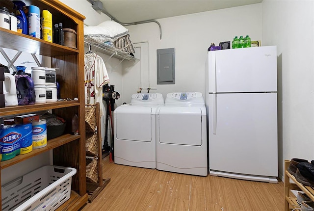 washroom with light wood-type flooring, electric panel, and washer and dryer