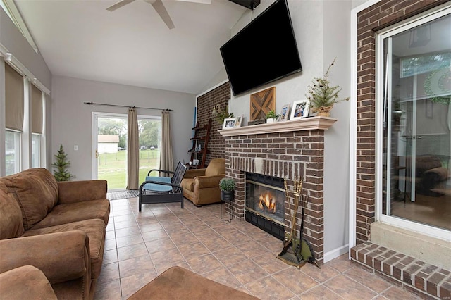 tiled living room featuring a brick fireplace, lofted ceiling, and ceiling fan