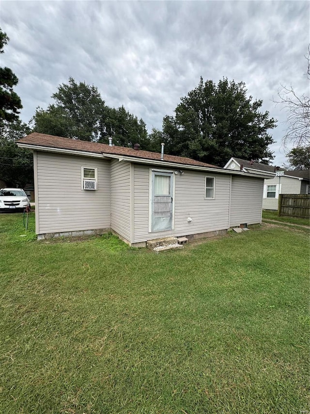 rear view of house featuring a yard