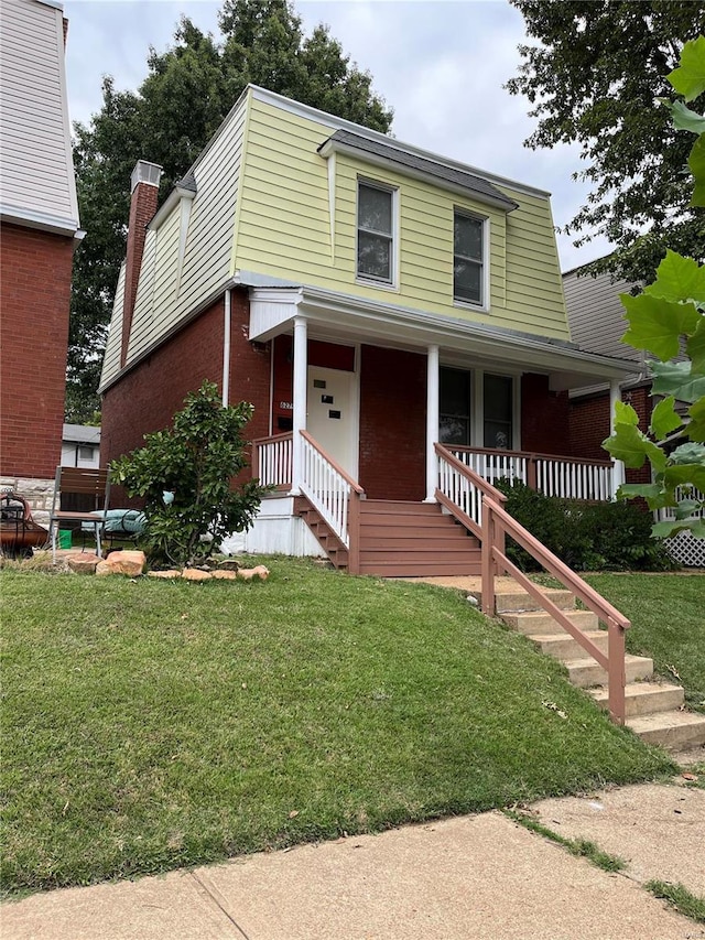 view of front of house with a front yard and a porch