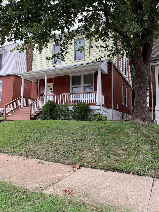 view of front of property featuring a front lawn and covered porch