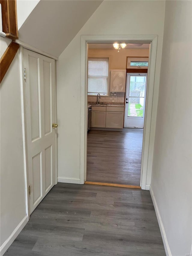 hallway with sink, vaulted ceiling, and dark hardwood / wood-style floors