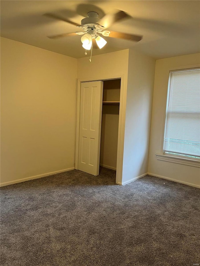 unfurnished bedroom featuring a closet, ceiling fan, and dark carpet