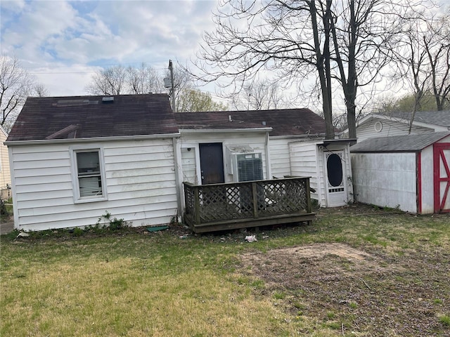 back of house with a storage shed and a yard