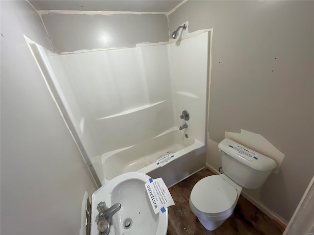 bathroom with wood-type flooring, shower / washtub combination, and toilet