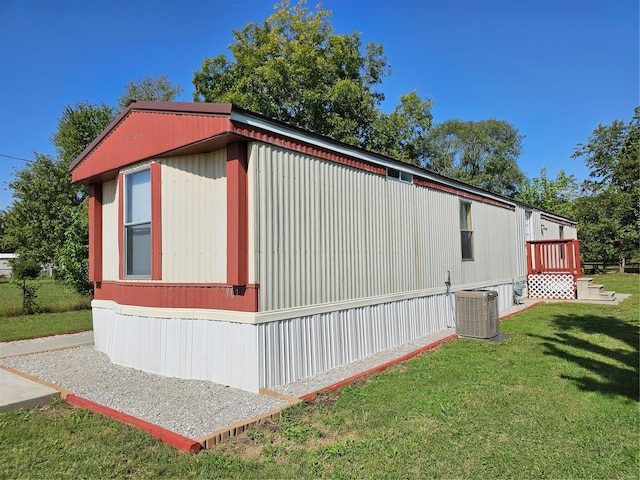 view of side of home with a lawn and central AC