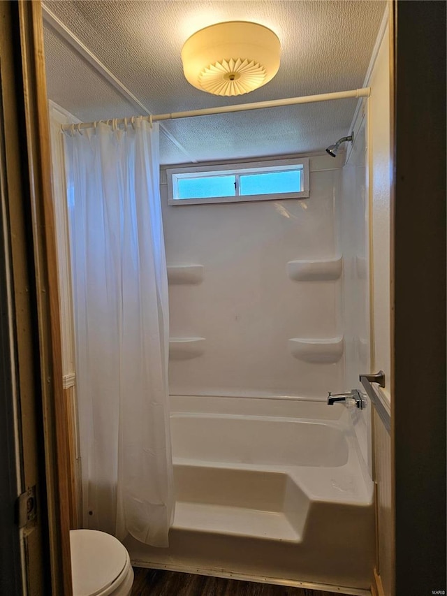 bathroom with hardwood / wood-style flooring, toilet, a textured ceiling, and shower / tub combo with curtain