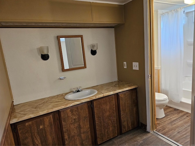 full bathroom with shower / bath combination with curtain, hardwood / wood-style floors, vanity, and toilet