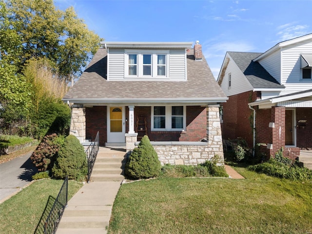 view of front facade with a front yard and covered porch