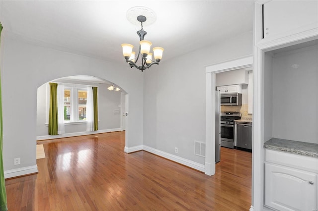 unfurnished dining area with dark wood-type flooring and a chandelier