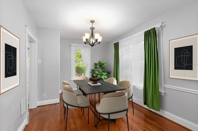 dining area featuring an inviting chandelier and hardwood / wood-style flooring