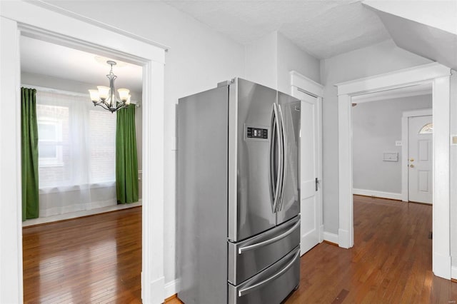 kitchen featuring dark wood-type flooring, a chandelier, stainless steel fridge, and a textured ceiling