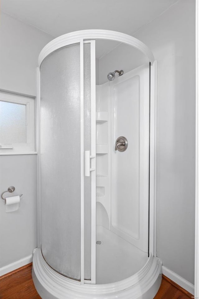 bathroom featuring hardwood / wood-style flooring and a shower with door