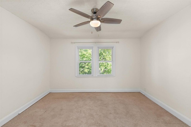 carpeted empty room with ceiling fan and a textured ceiling