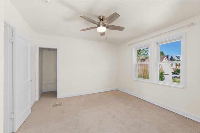 unfurnished room featuring ceiling fan and light carpet