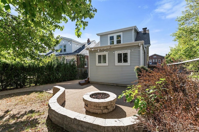 back of house with an outdoor fire pit and a patio area