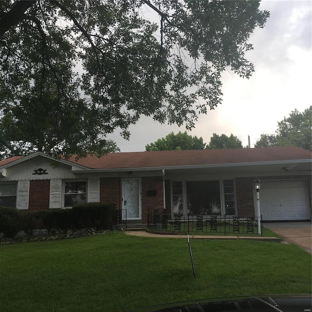 ranch-style home featuring a garage and a front lawn