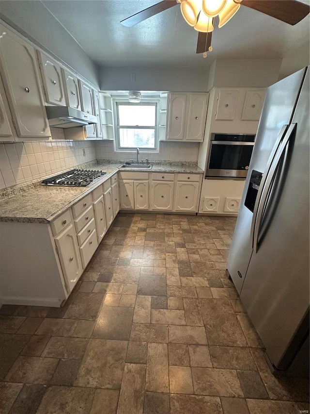 kitchen featuring sink, white cabinets, ceiling fan, stainless steel appliances, and backsplash