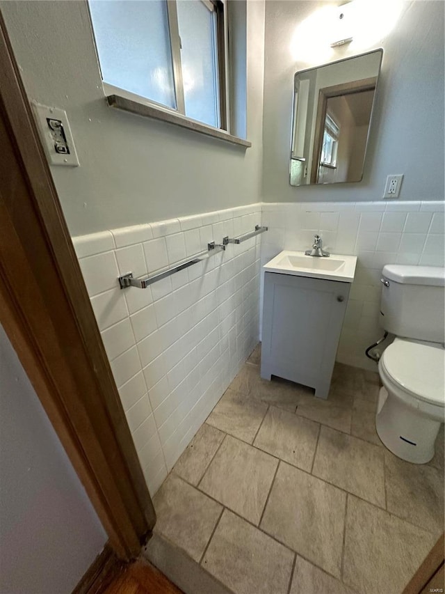 bathroom with tile walls, vanity, and toilet