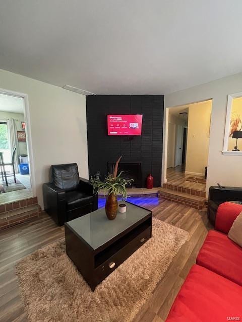 living room featuring a large fireplace and hardwood / wood-style floors