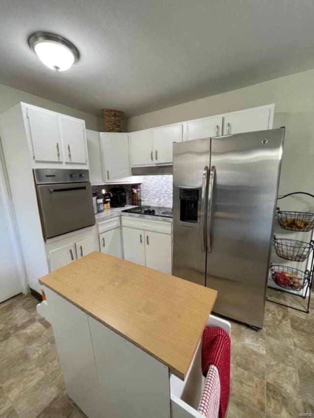 kitchen with black appliances, backsplash, and white cabinets